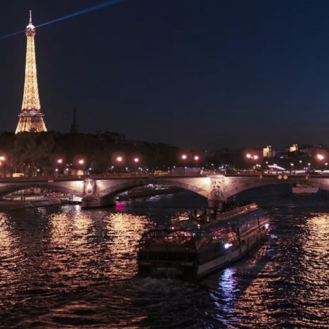 Rio Sena em Paris com a Torre Eiffel e barcos ao longo das margens.